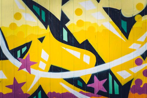 Free Colorful abstract graffiti art featuring yellow and purple design on a wall. Stock Photo