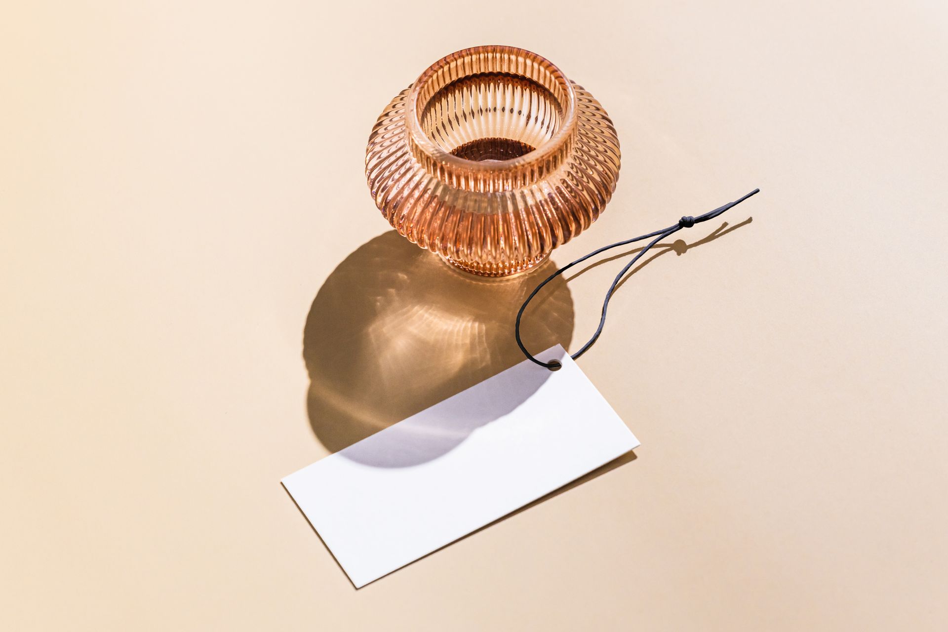 Elegant glass vase with a blank tag for customizable branding or labeling, perfect for product presentations.