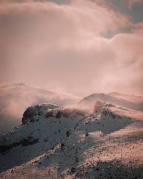A mesmerizing view of snow-covered peaks beneath cloudy skies in Turkey. Winter serenity captured.