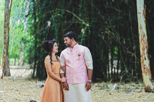 Free A loving couple embraces in traditional clothing outdoors, surrounded by nature. Stock Photo