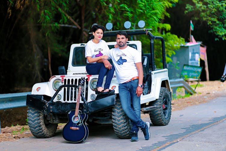 Man And Woman Sitting On A White Jeep