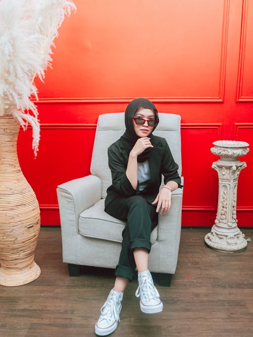 Free Woman Wearing Sunglasses Sitting on Gray Armchair  Stock Photo