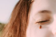 Brown and White Butterfly on Womans Left Cheek