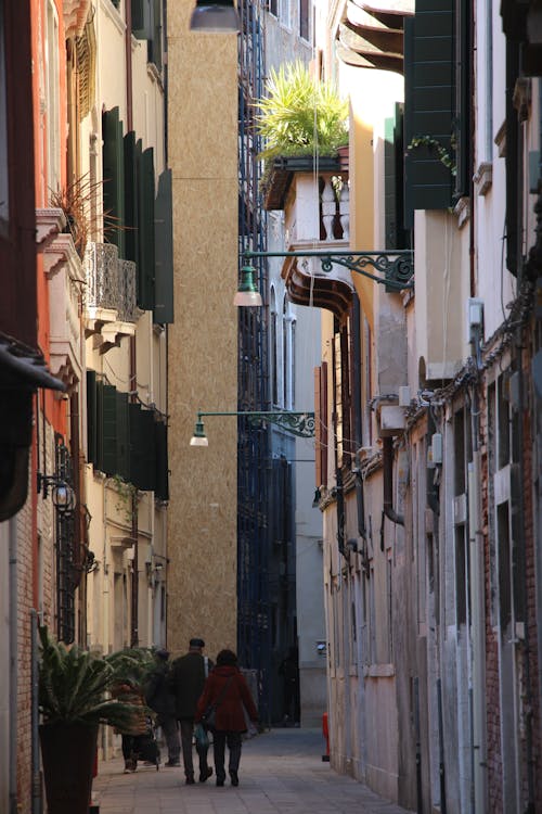 People Walking on Narrow Alley Between Houses