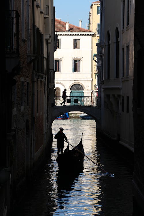 A Gondola Passing Under a Bridge