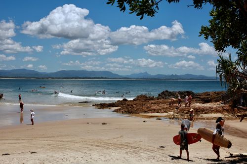 Free A vibrant coastal scene featuring surfers, tourists, and sunny shores, ideal for vacation imagery. Stock Photo
