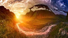 山间河流上，日落令人惊叹，云层壮观，景象充满活力