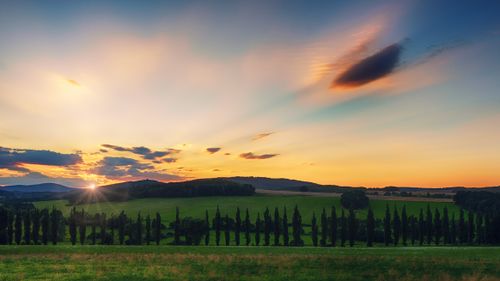 Free Beautiful sunset over a tranquil farmland, with vibrant colors and peaceful scenery. Stock Photo