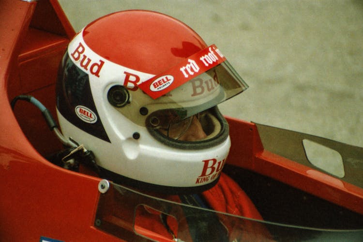 A Man With Red Helmet Inside A Race Car