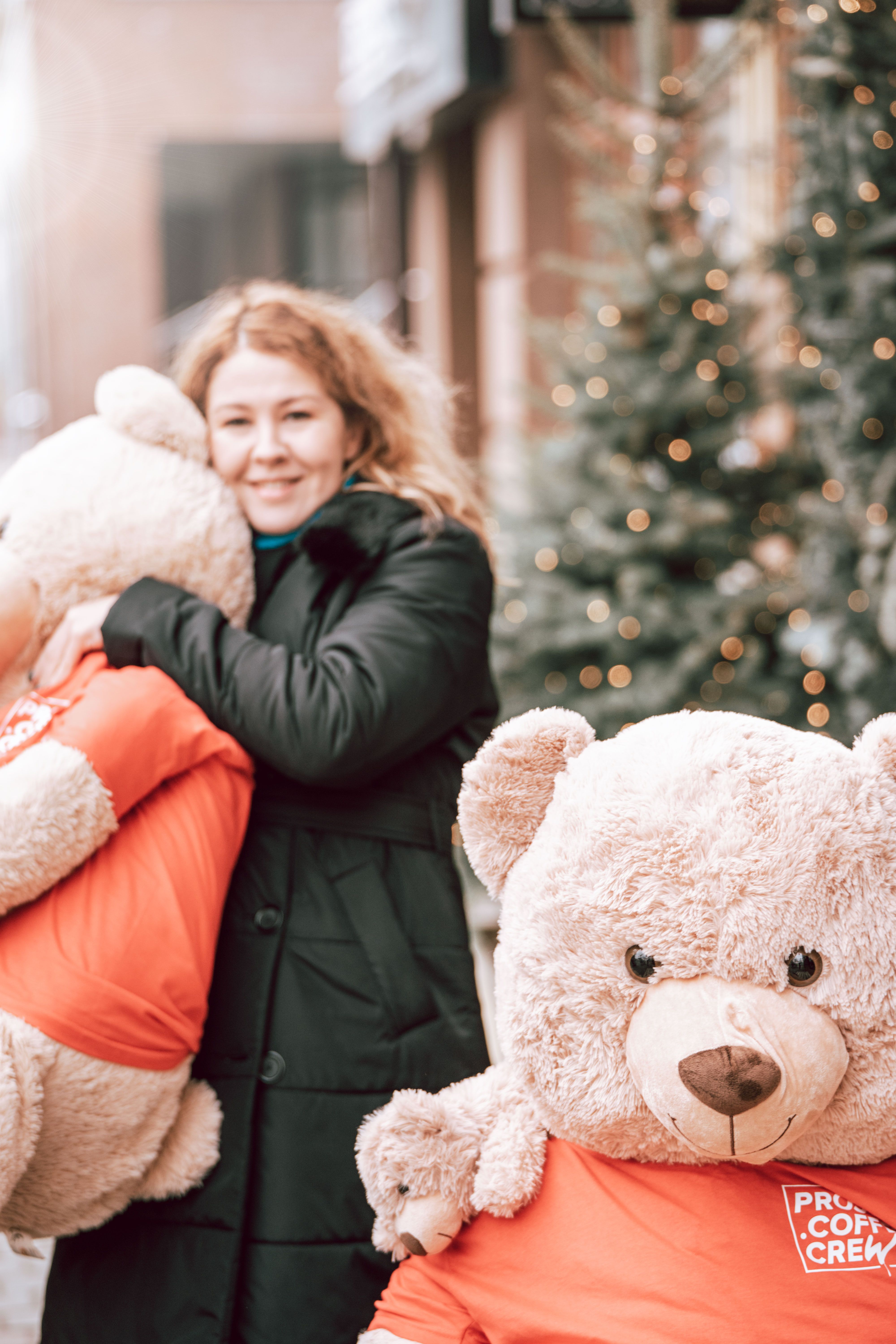 Woman in Black Jacket Hugging a Brown Bear Plush Toy · Free Stock Photo