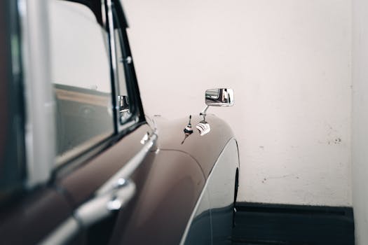 Close-up of a classic vintage car showcasing elegant curves and chrome detailing, emphasizing its timeless design.