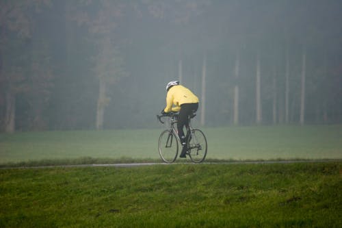 Photo of a Person Riding a Bicycle Near Grass