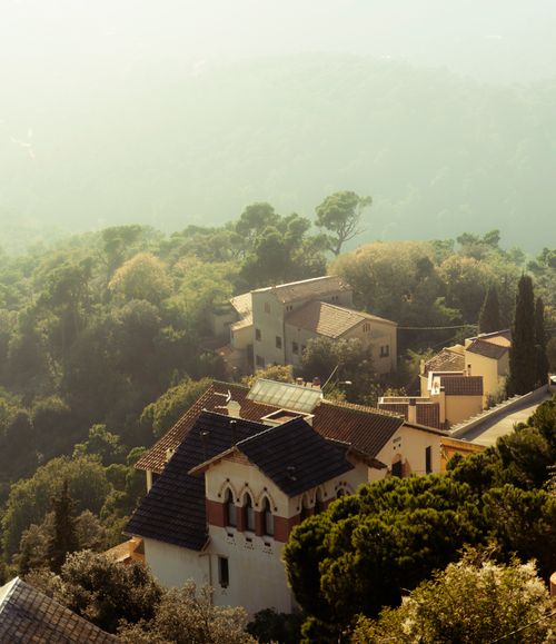 Free A beautiful view of a misty village in the Italian countryside surrounded by lush greenery. Stock Photo