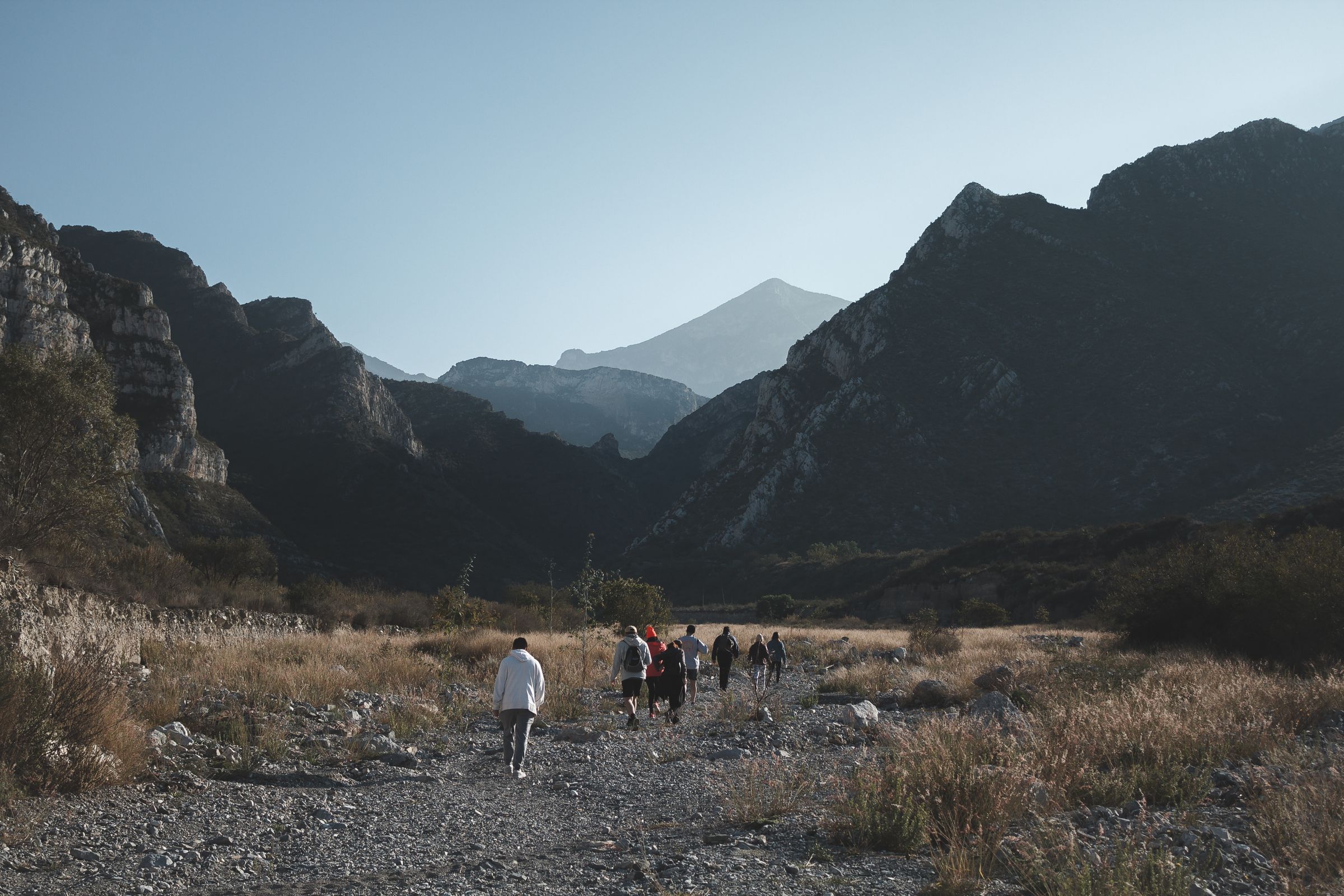 A group of travellers walking together through a rocky mountain valley