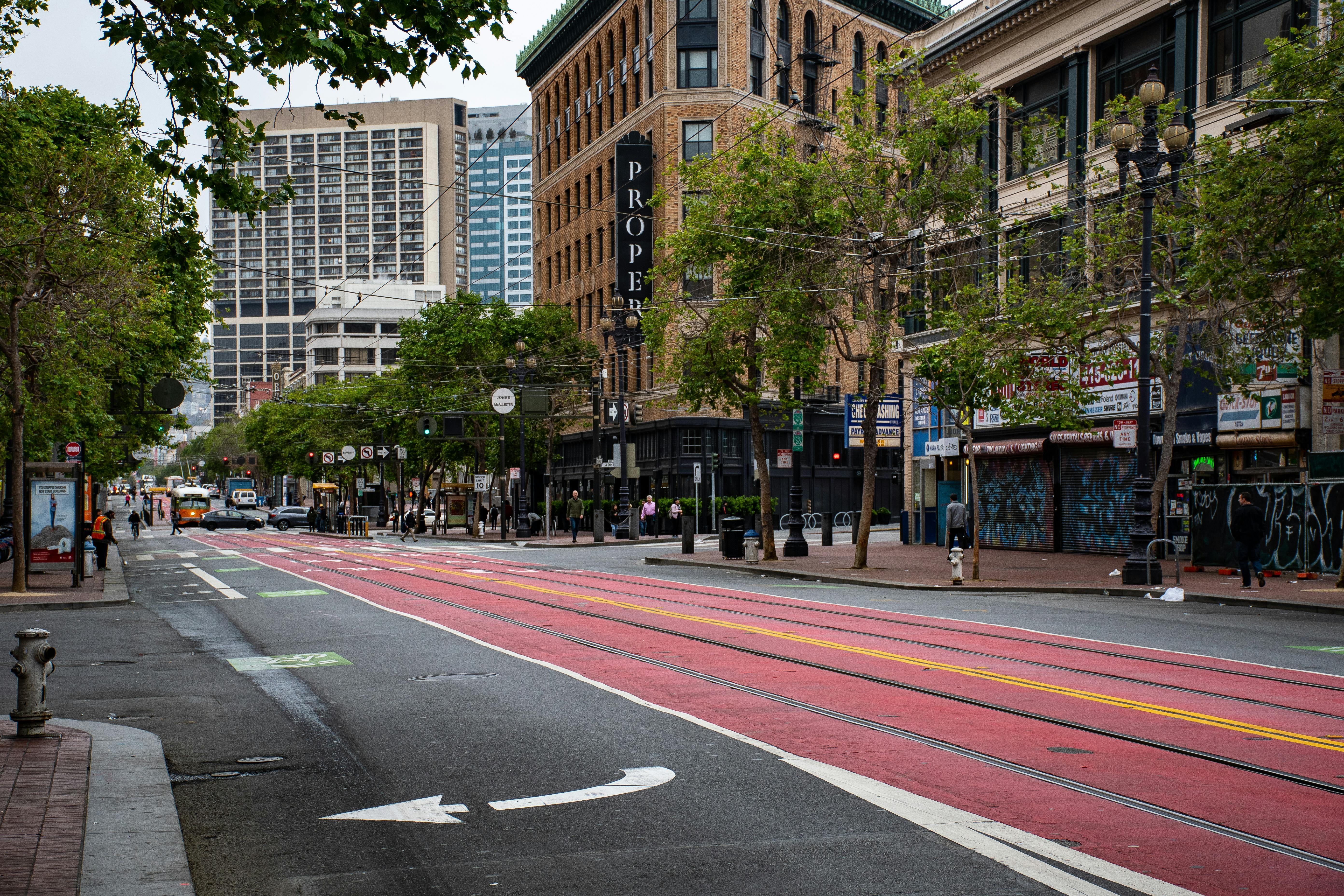 A colorful downtown street with buildings and sparse foot traffic during the day.