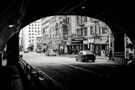 透过隧道，可以看到城市街道上汽车和行人的黑白照片