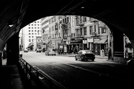 透过隧道，可以看到城市街道上汽车和行人的黑白照片