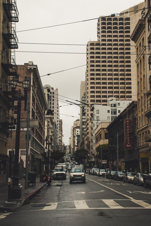 Free Bustling city street scene with high-rise buildings and cars, capturing urban life. Stock Photo