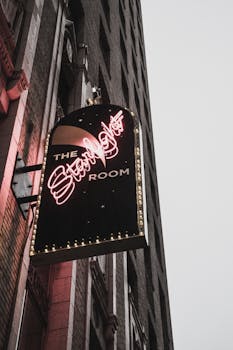 Low-angle view of illuminated neon signage for The Starlight Room on a city building.