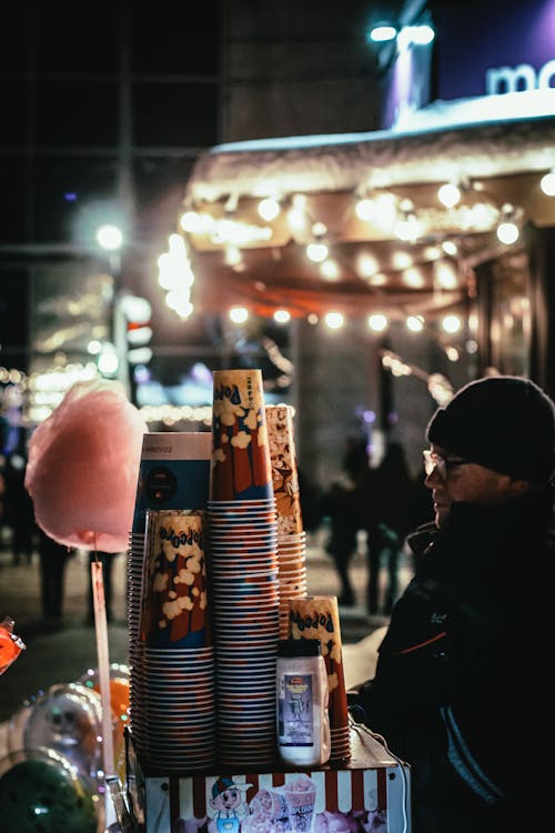 Photograph of a Man Standing Near Cups