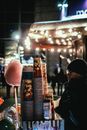Man in Black Jacket and Knit Cap Standing Near Red and White Lighted Street Light during