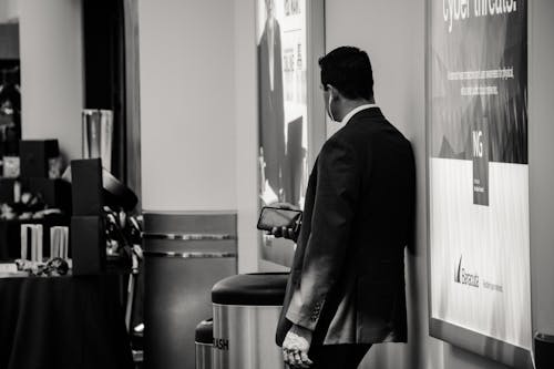 Man in Suit Jacket Near Poster