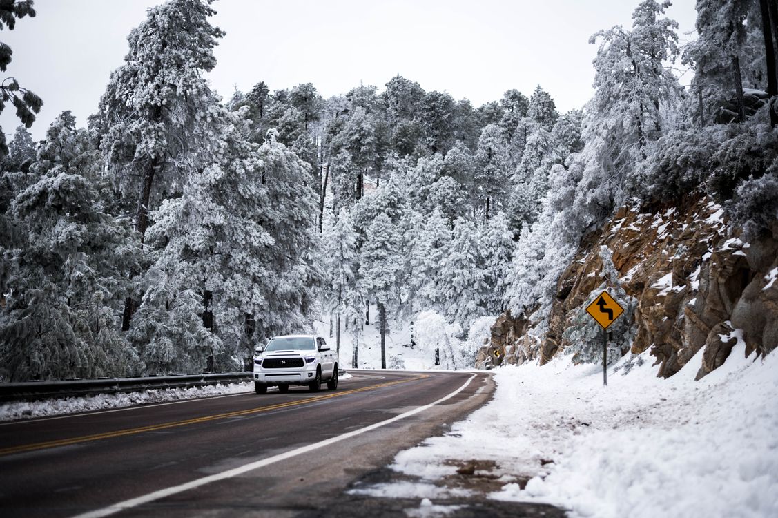 White Car Driving on the Road in the Snowy Mountains · Free Stock Photo
