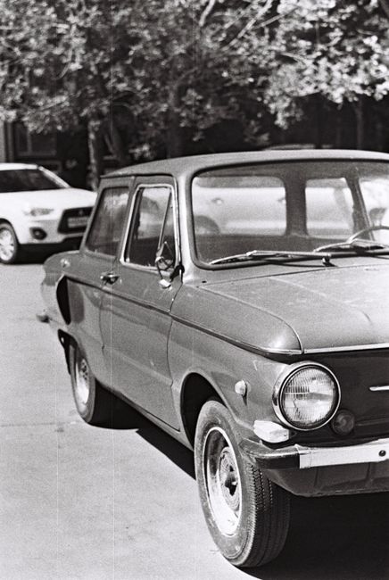 Classic vintage car parked in urban setting captured in black and white for timeless appeal.