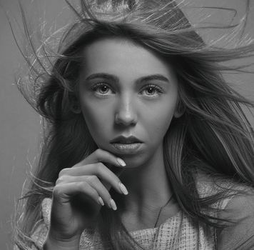 Striking black and white portrait of a woman with flowing hair and a thoughtful pose.