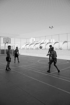 Four young men playing a fun game of basketball on an outdoor court.