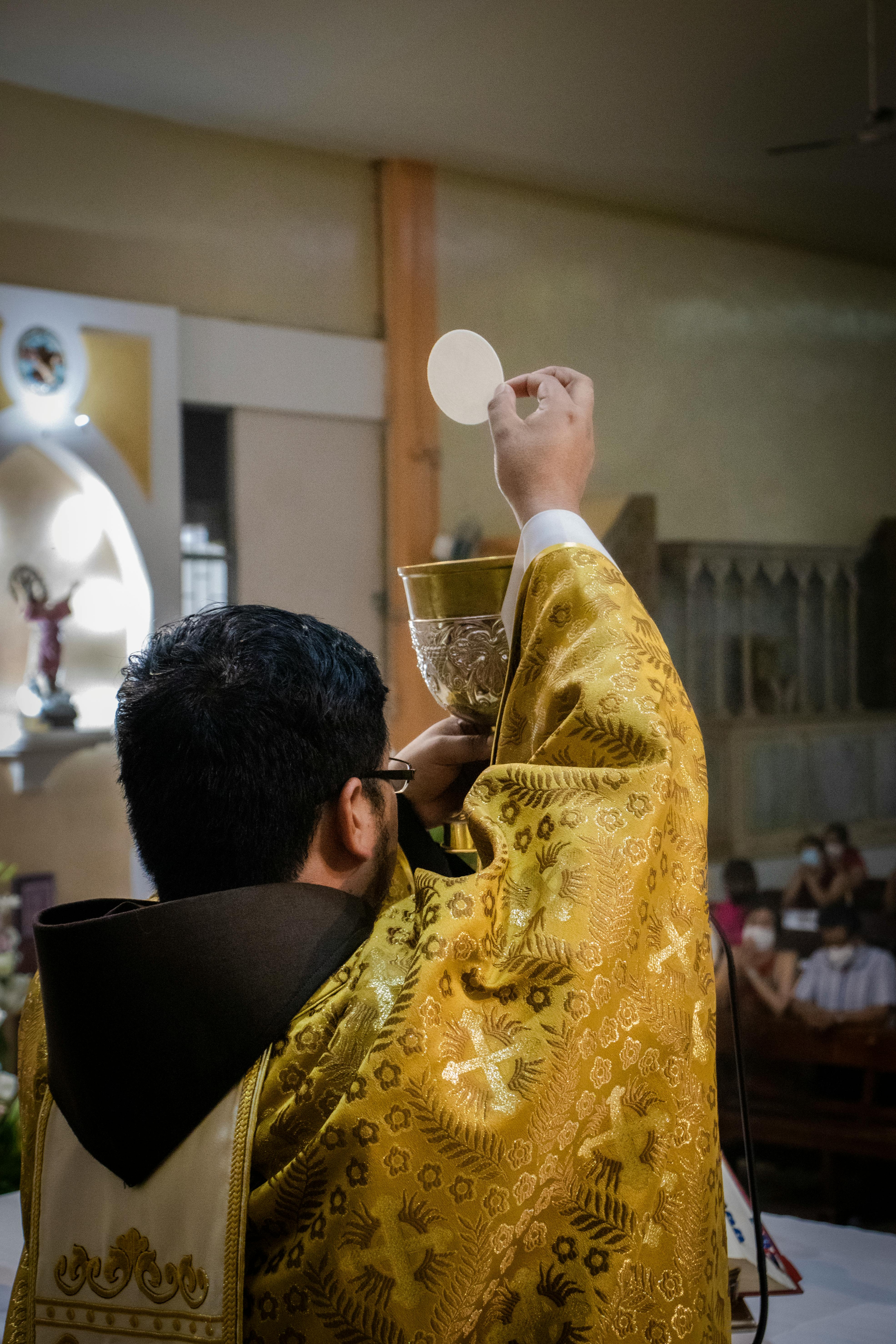 a priest doing the consecration at a holy mass