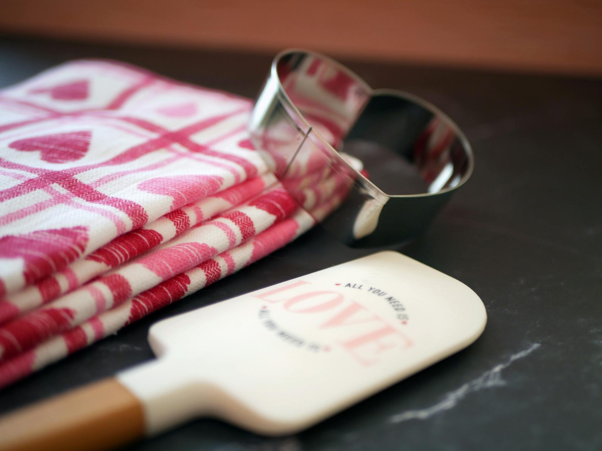 Close-up of heart-shaped cookie cutter and themed cloth for Valentine's Day.
