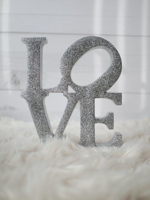 Word Love in Silver Letters on White Fur Textile
