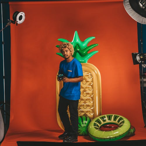 Man Standing with Photo Camera in Hands in Amateur Studio