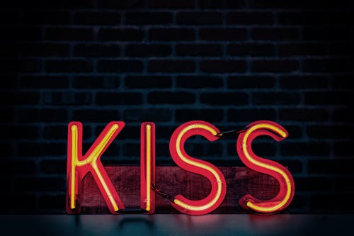 Free неоновая вывеска Red Kiss в темной комнате Stock Photo