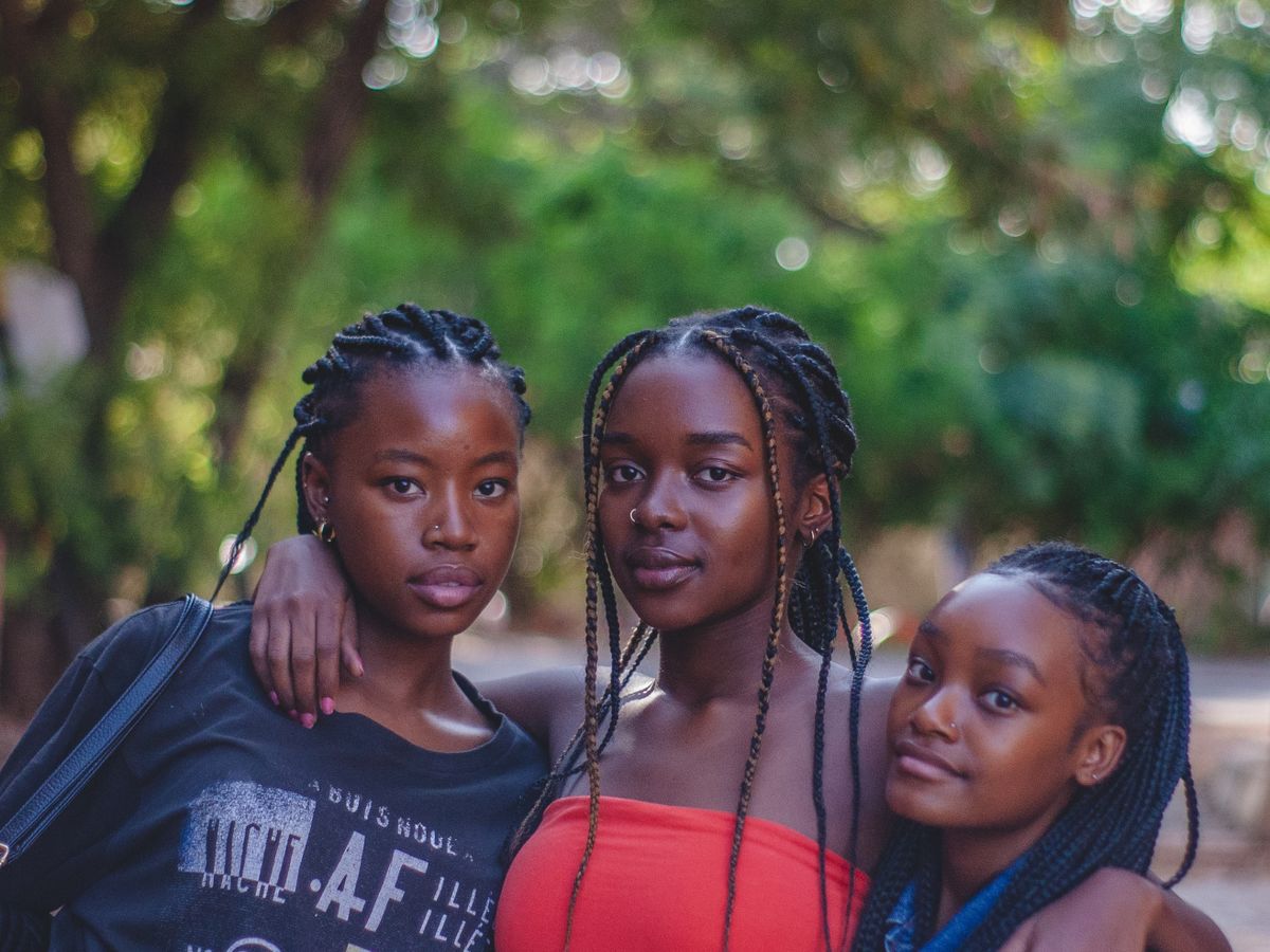 Teen friends with braided hair posing together outdoors