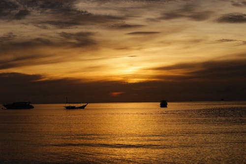 Silhouette of Boats on the Sea during Sunset
