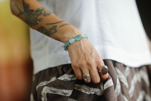 Free A tattooed arm adorned with rings and a bracelet, emphasizing personal style. Stock Photo