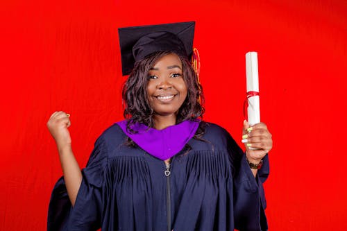 Woman in Graduation Gown Holding a Diploma