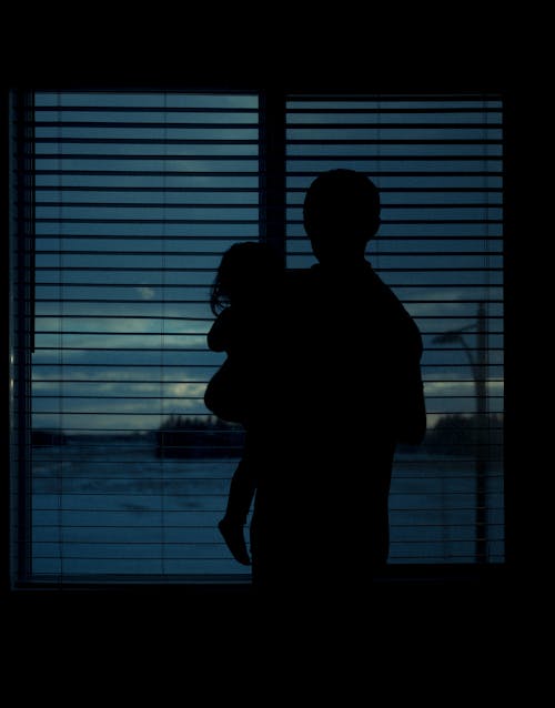 Silhouette of a Person Carrying a Child
