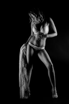 Elegant black and white studio portrait of a woman in lingerie, embracing sensuality.