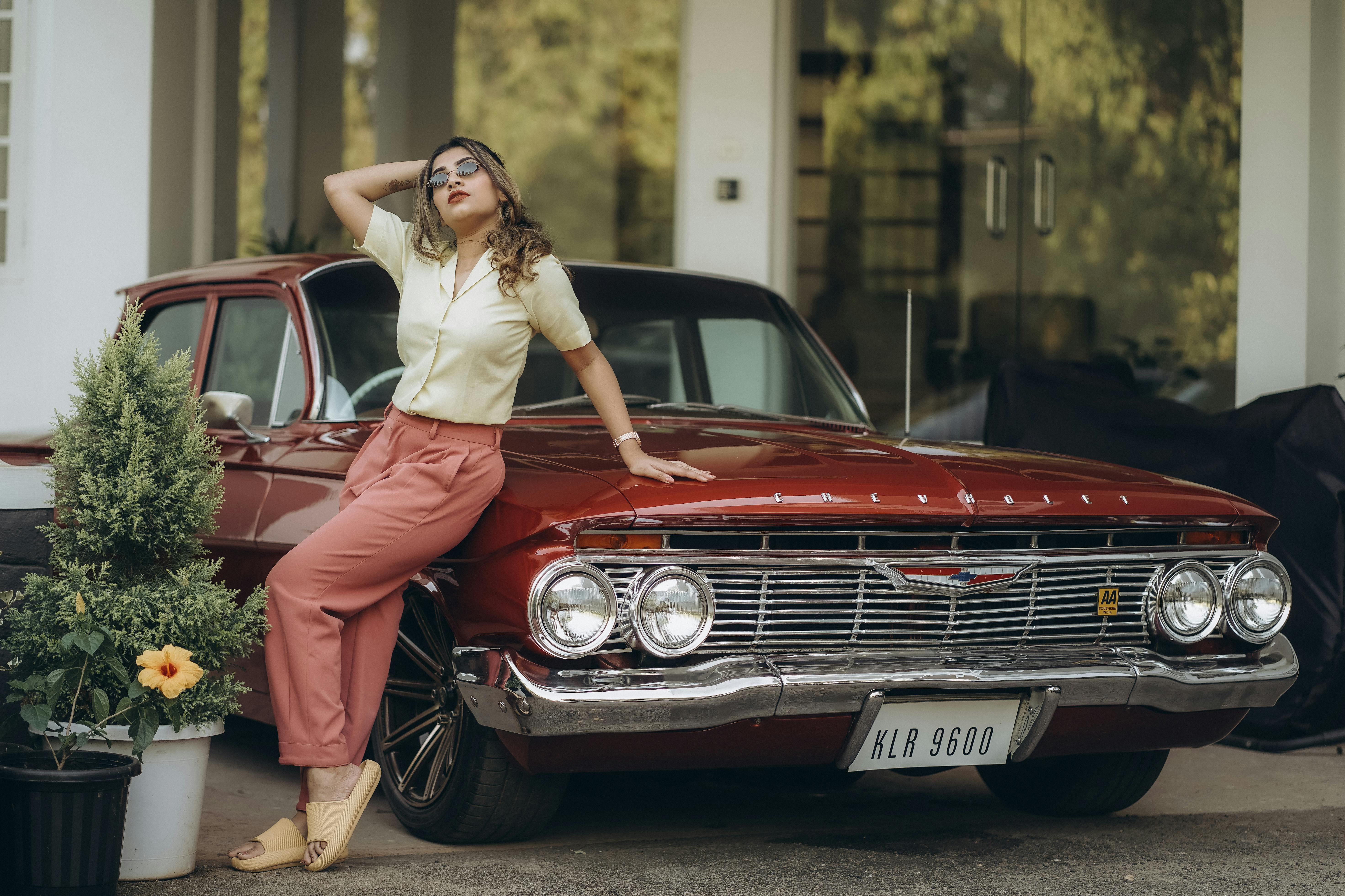 Blond Woman Leaning against Red Vintage Car  Free Stock Photo