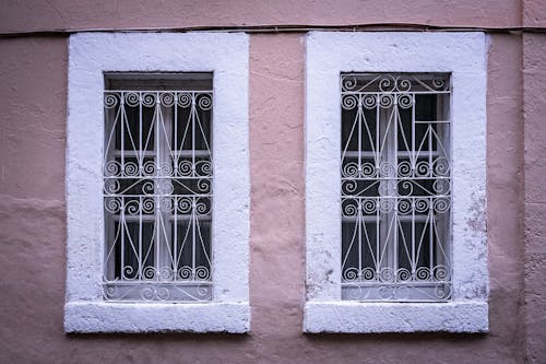 Free Windows with Metal Railings on Pink Concrete Wall Stock Photo