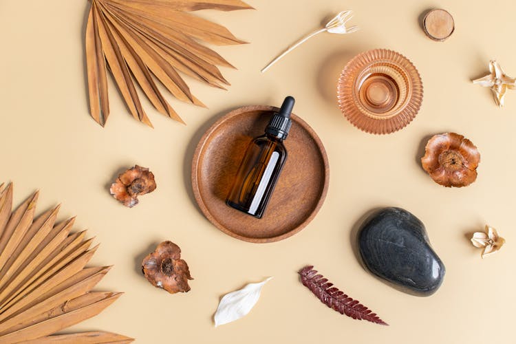 Natural Oil In Brown Bottle Laying On Wooden Plate