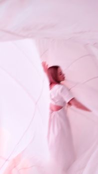 Artistic blurred portrait of a woman in white, creating a serene and ethereal atmosphere.
