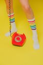 Unrecognizable Female Legs in Socks and Orange Telephone