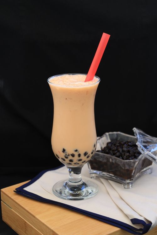 Free A refreshing glass of boba milk tea with tapioca pearls and a pink straw. Stock Photo