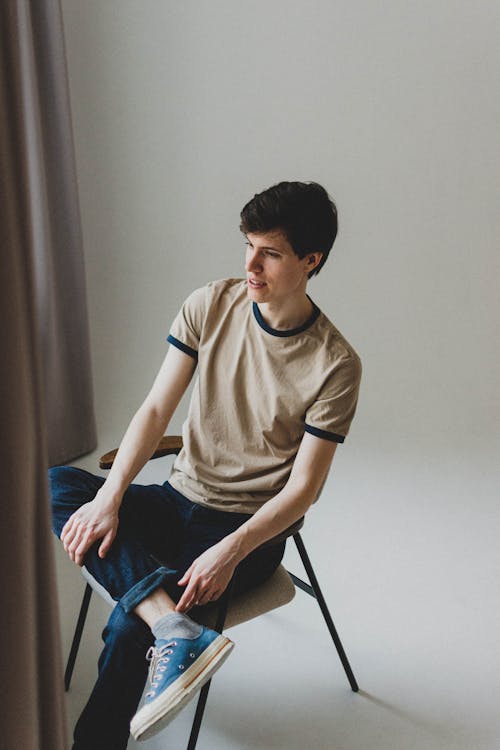 Young Man Sitting Posing in Studio 