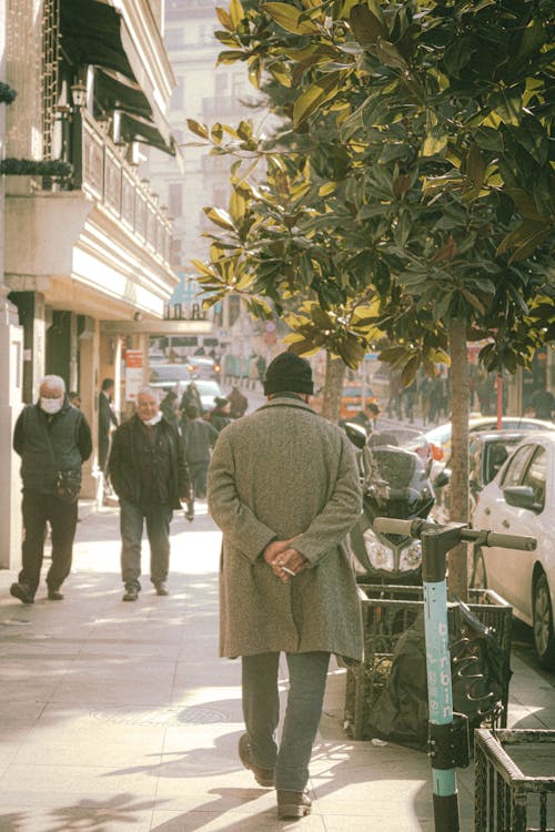 Back View of a Person Walking on a Sidewalk