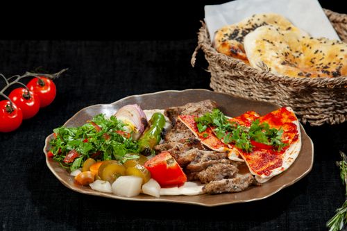 Free Savor the flavors of Middle Eastern cuisine with this grilled meat platter and fresh herbs. Stock Photo